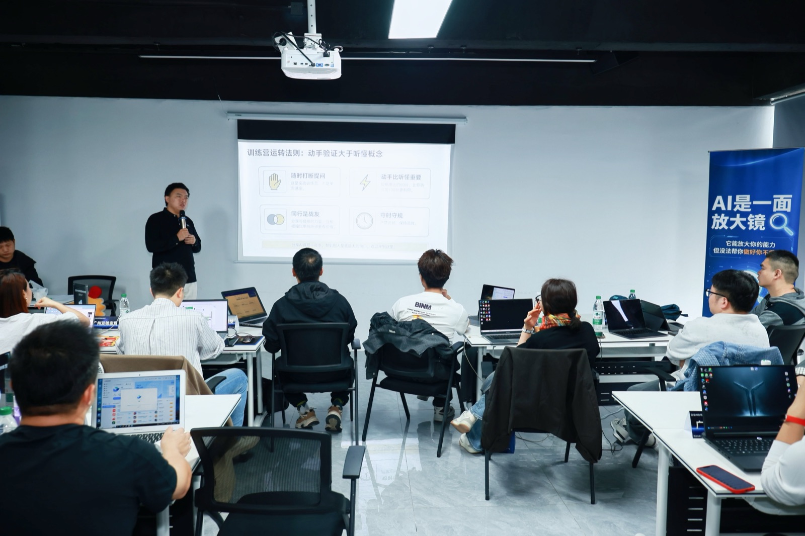 周周AI训练营课堂中，学员围绕电脑和投影内容共同操作